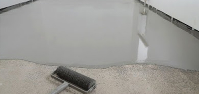 Worker applying coating to concrete planter box