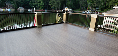 Person using roller to apply coating to deck